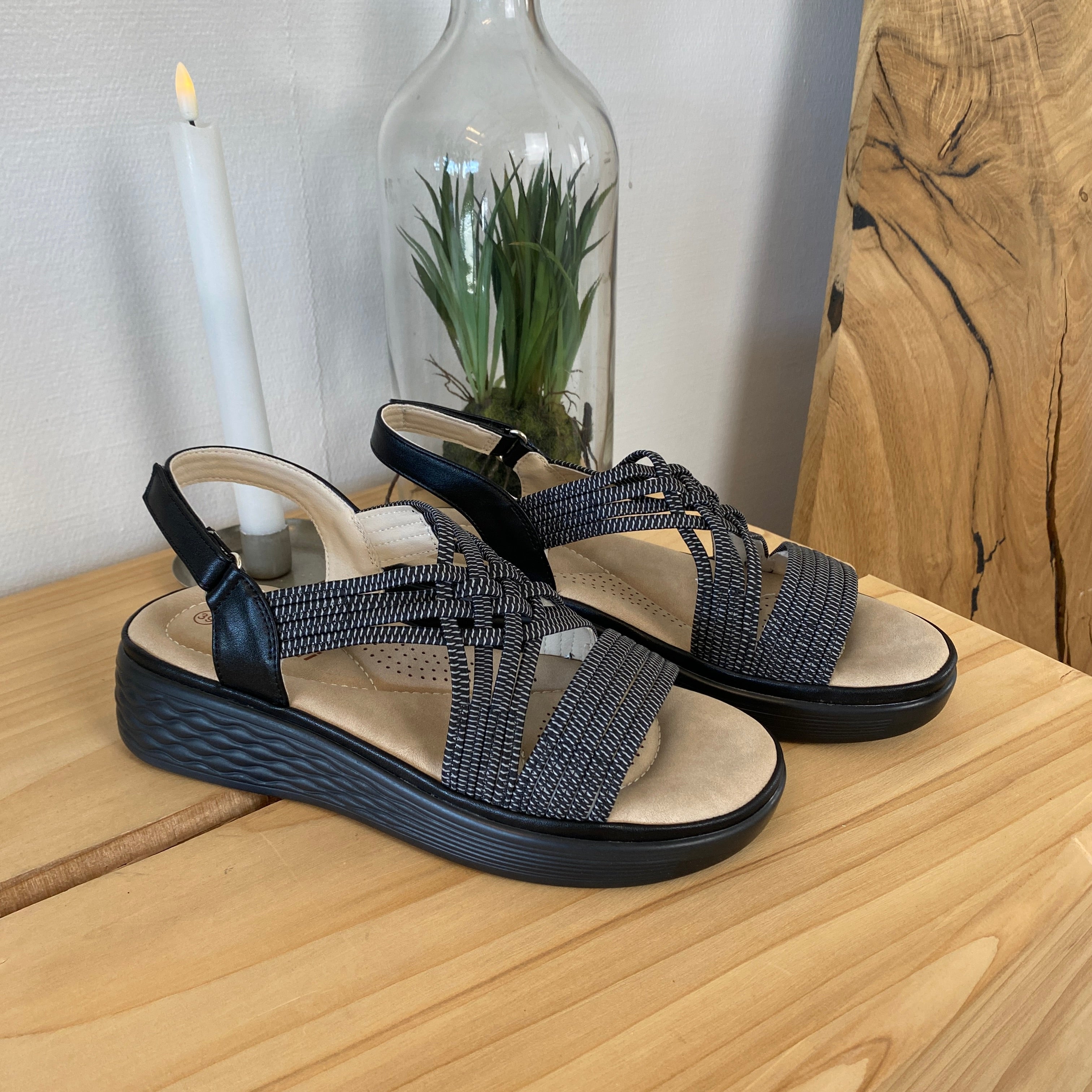 Svart sandal med elastiske stropper og støtabsorberende såle