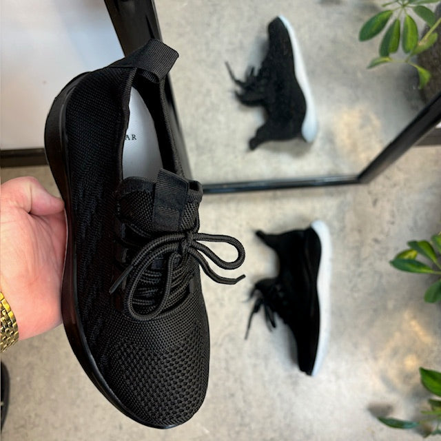 Sorte strikkede slip-on-sko med fast kant ved åpningen
