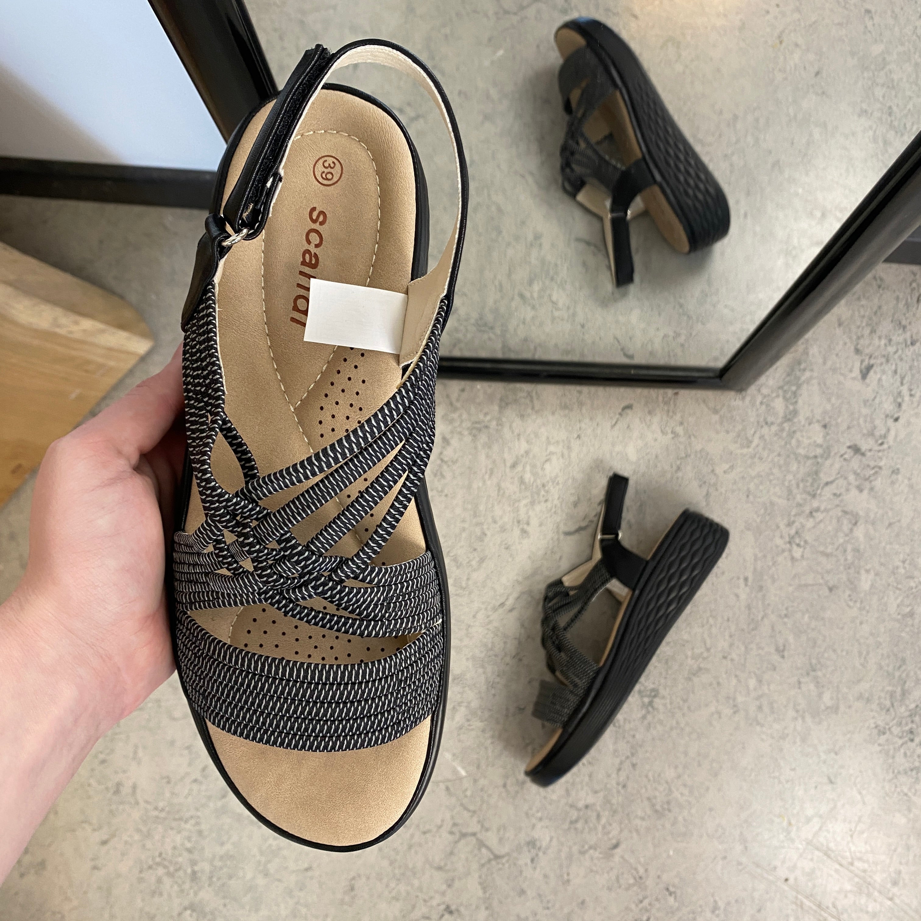 Svart sandal med elastiske stropper og støtabsorberende såle