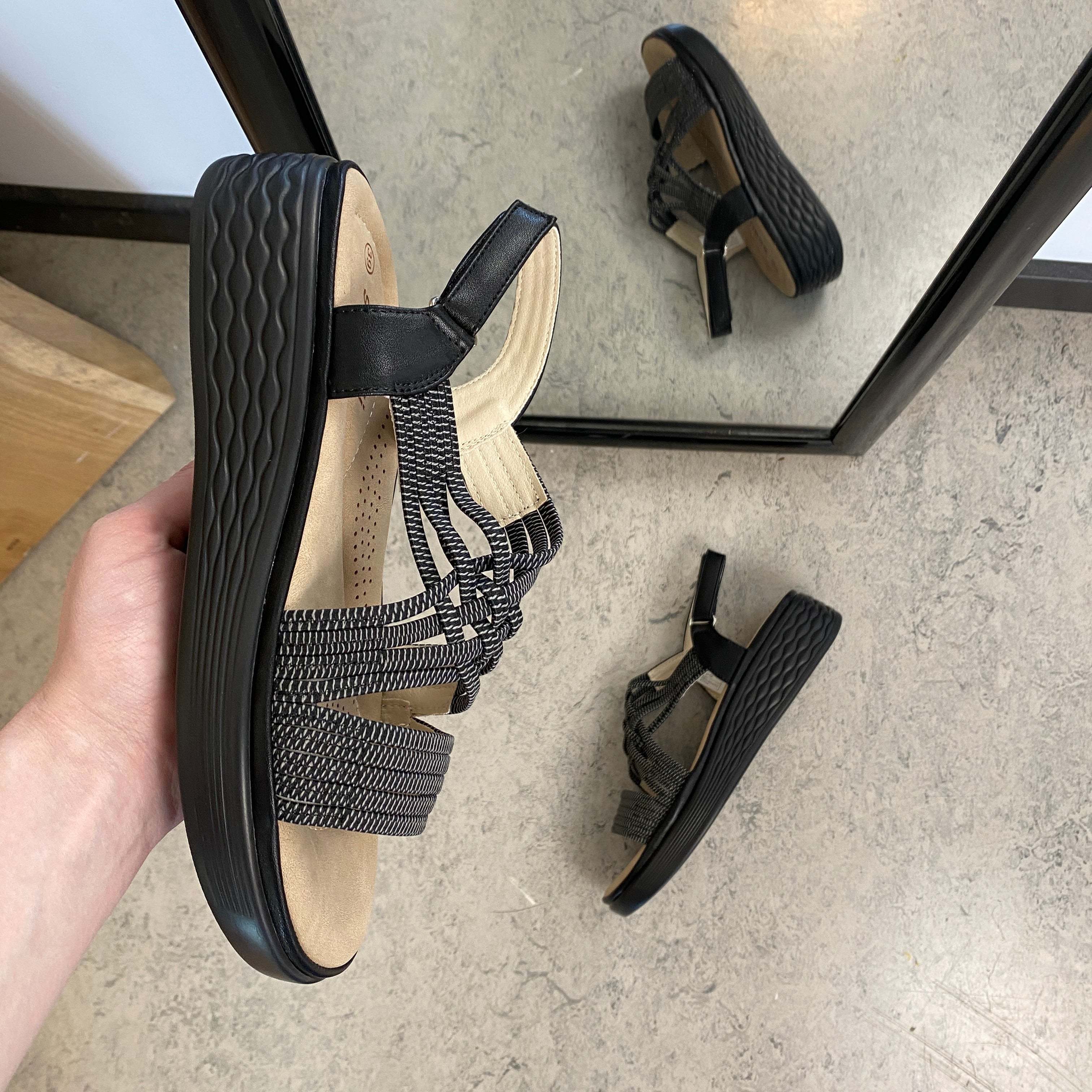 Svart sandal med elastiske remmer og støtabsorberende såle