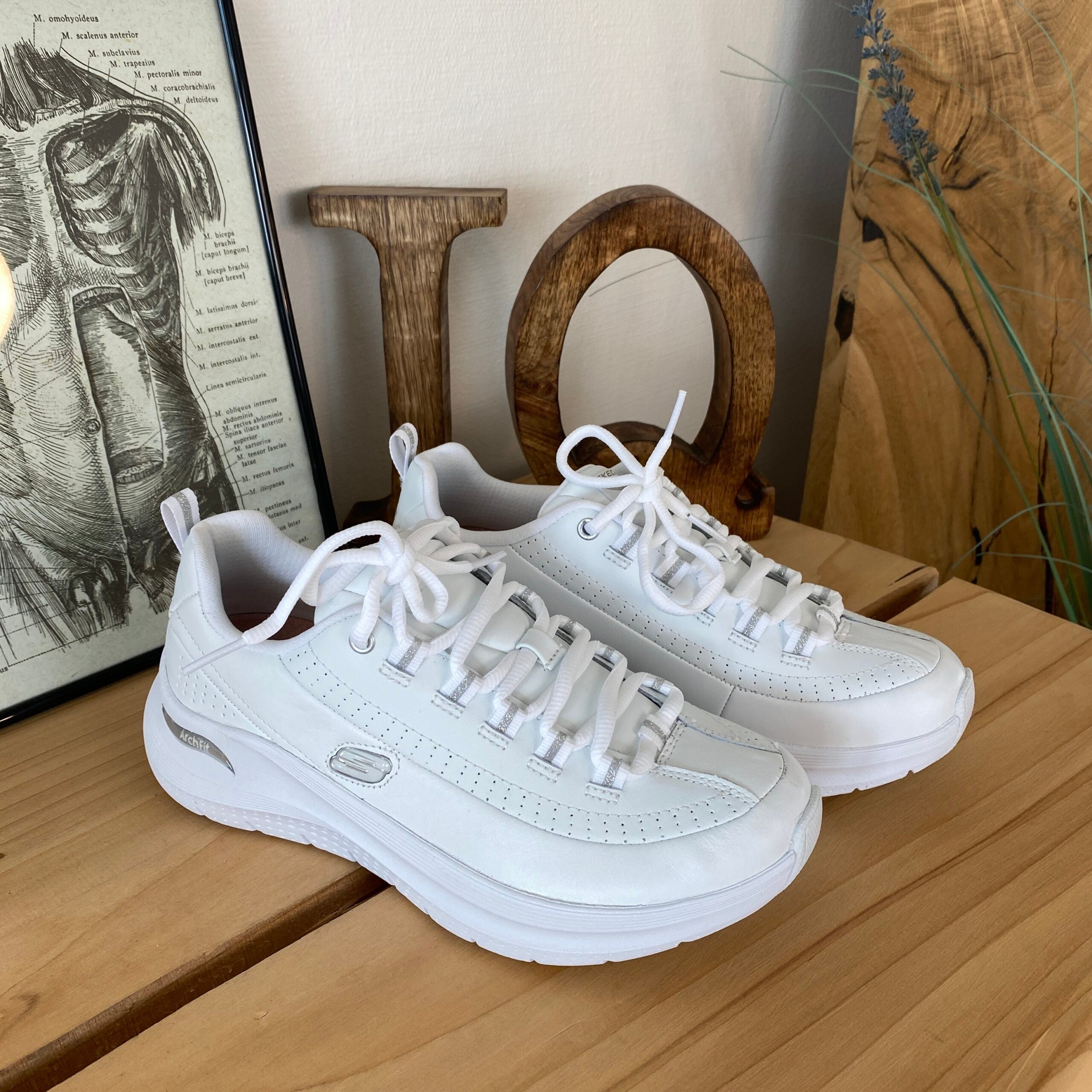 Hvite Skechers med glatt skinnoverflate