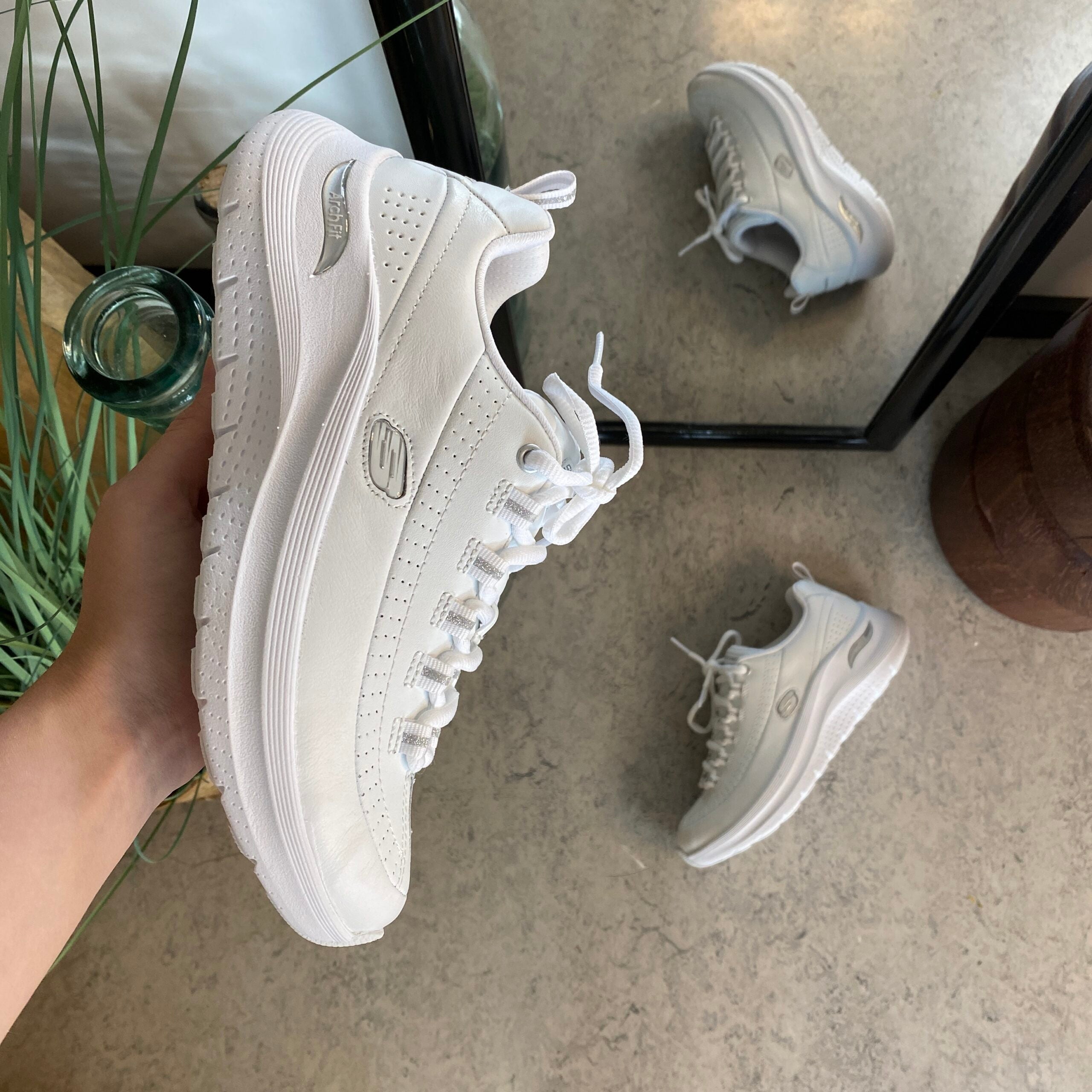 Hvite Skechers med glatt skinnoverflate