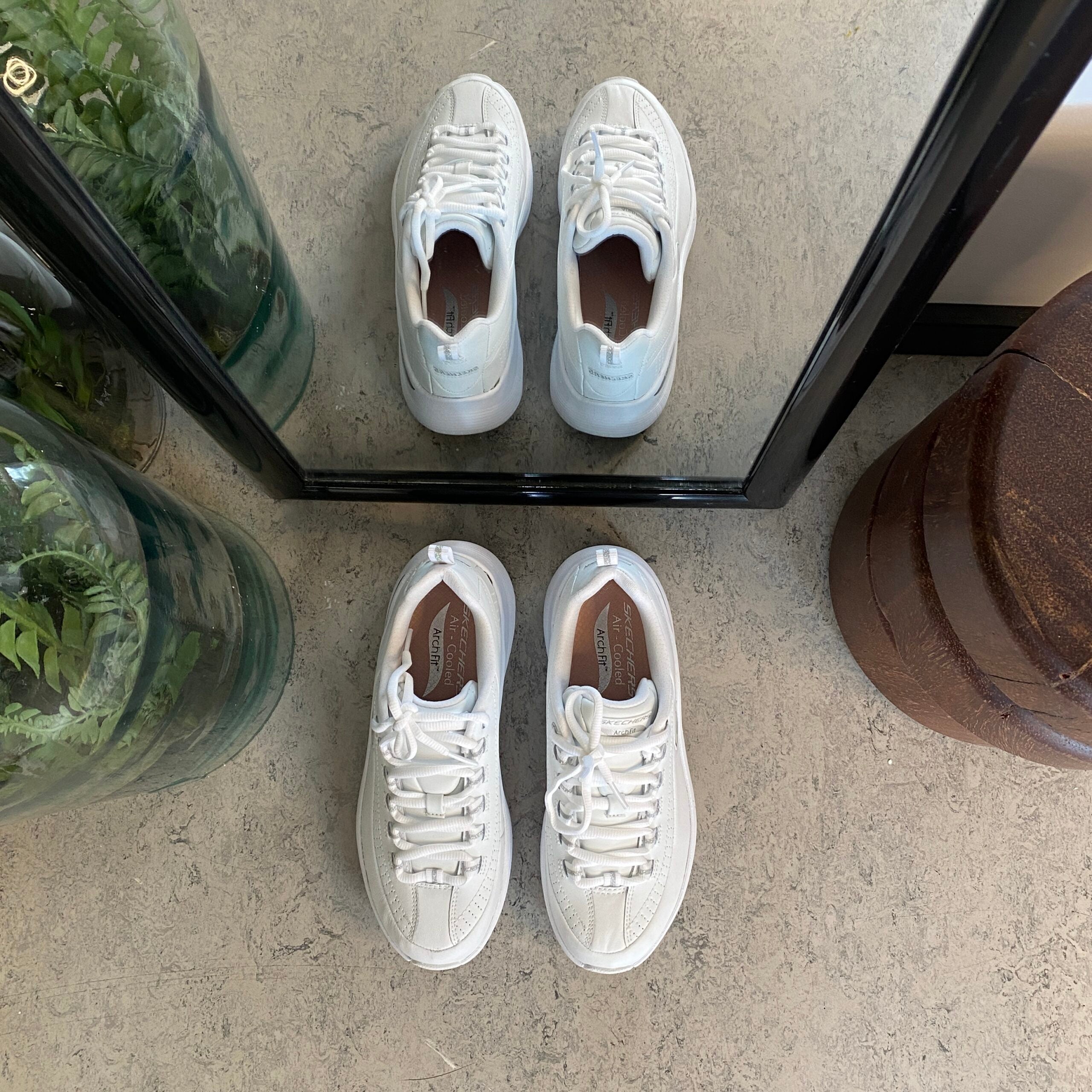 Hvite Skechers med glatt skinnoverflate