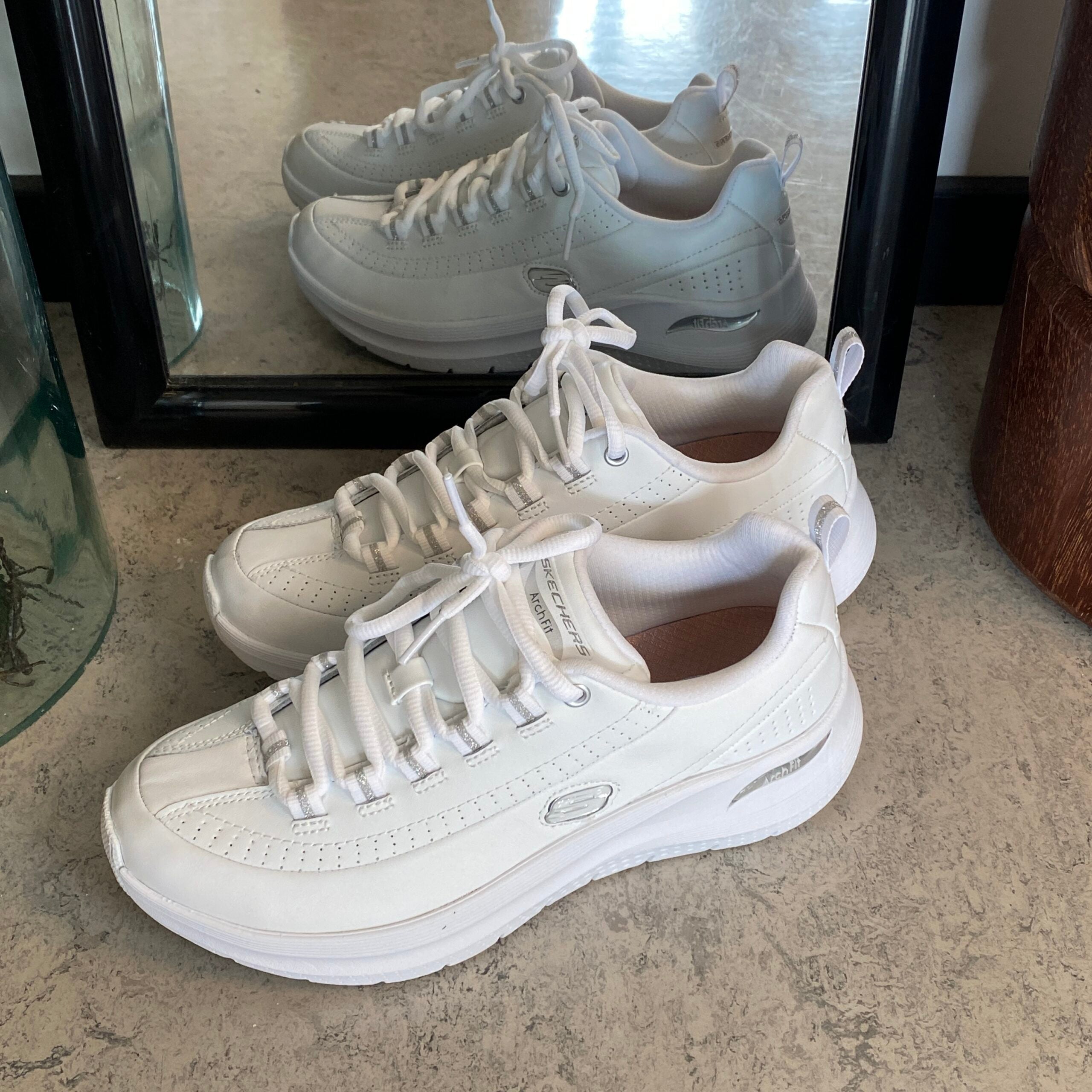 Hvite Skechers med glatt skinnoverflate
