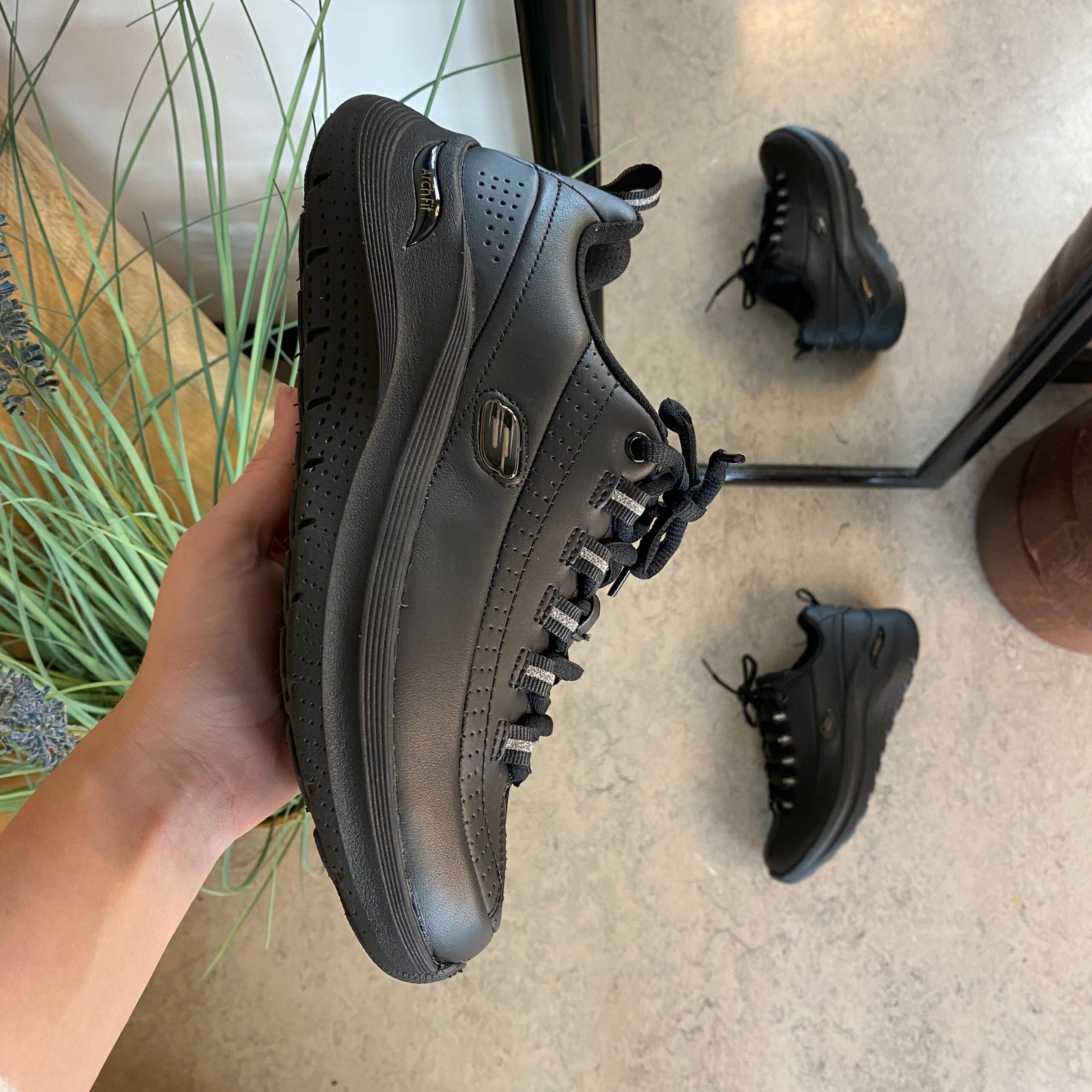 Svart Skechers med glatt skinnoverflate