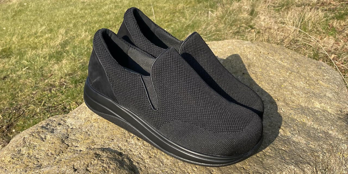 Svart hyttesko i strikket (knit) med fotformet såle