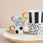 Krus med store svarte prikker og brun hank – moderne stentøykopp for kaffe og te
